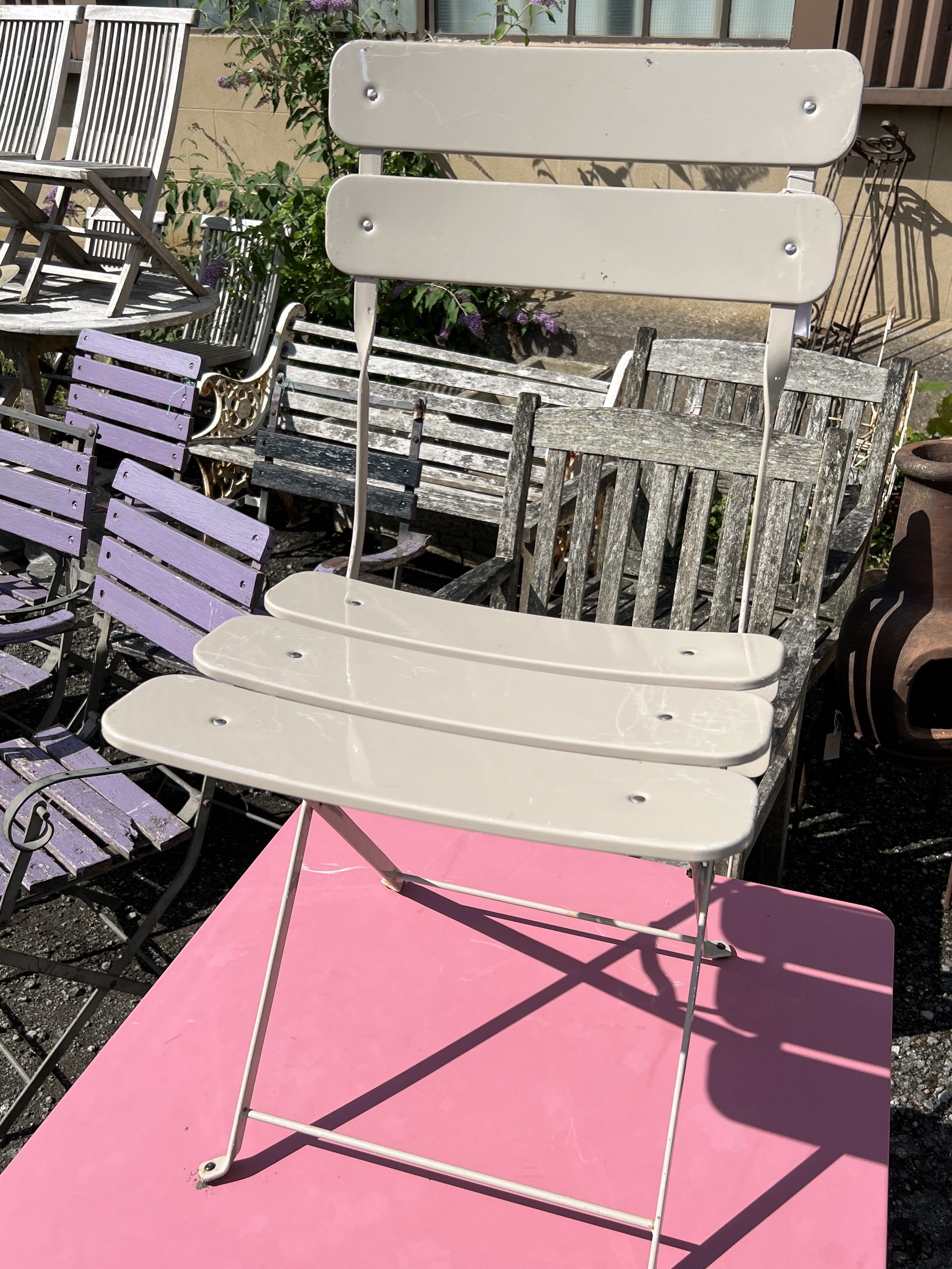 A square painted metal folding garden table, width 71cm, height 71cm and two metal folding garden chairs
